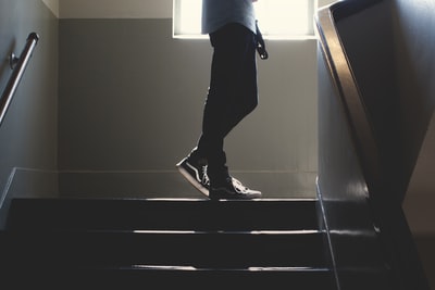人站在灯光幽暗的楼梯

